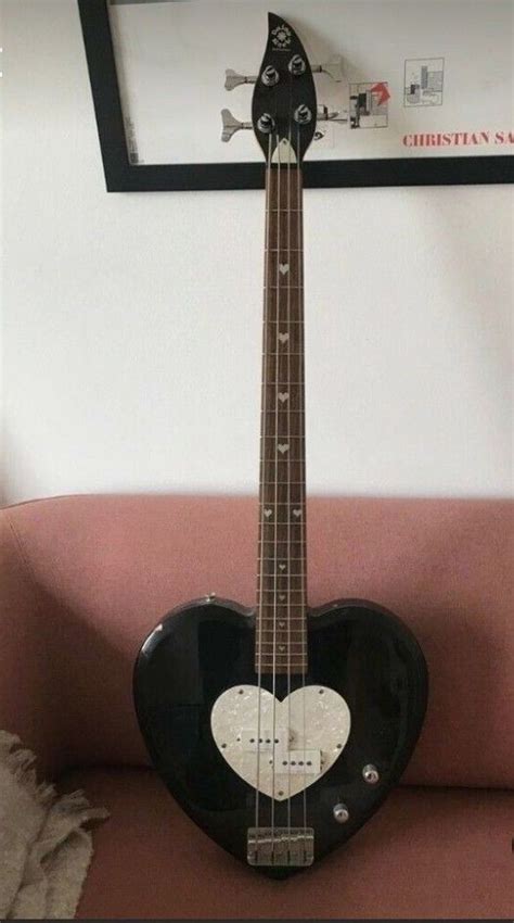 A Guitar Shaped Like A Heart Sitting On Top Of A Couch