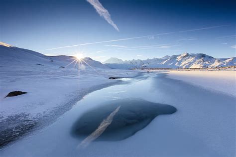 Blue Sky And Sun On Lake Piz Umbrail Surrounded By Snowy Peaks At