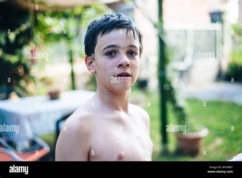 Porträt eines 13 jährigen Jungen im Sommer shirtless in seinem Garten