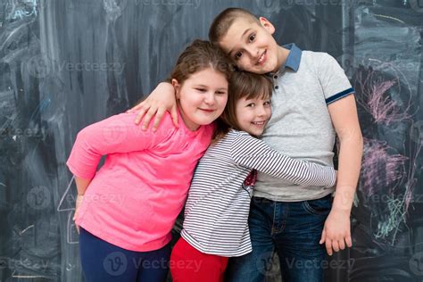 Group Of Kids Hugging In Front Of Chalkboard 10397575 Stock Photo At