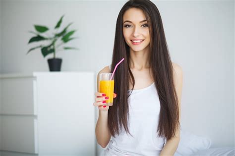 Premium Photo Casual Smiling Woman Holding A Glass Of Orange Juice