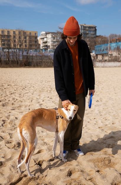 Perro Galgo Con Due O Masculino En La Playa Foto Gratis