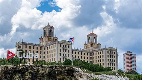 A Large Building With Two Towers And A Flag Flying In Front Of It On