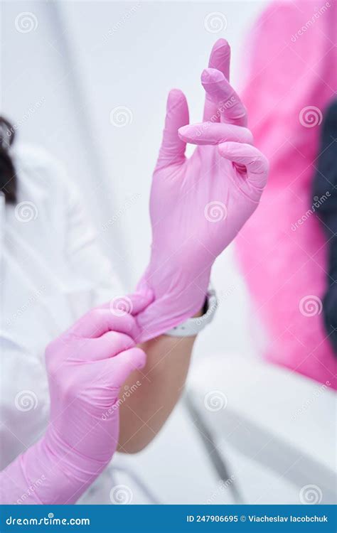 Close Up Photo Of Cosmetologist Hands Wearing Pink Nitrile Gloves Stock