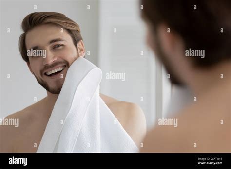 Mirror Reflection Smiling Young Man Wiping Face With White Towel Stock