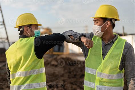 Engineers Man Wearing Face Mask And Touching With Elbow In Building