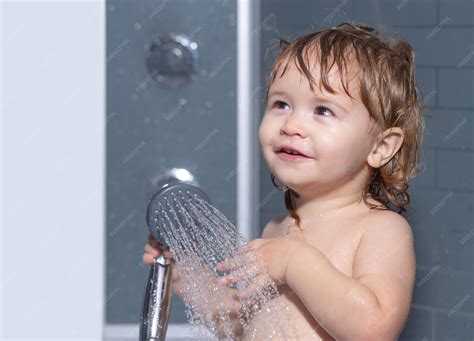 Criança No Banho - Criança tomando banho sob um chuveiro lavando bebê adorável no banheiro ...