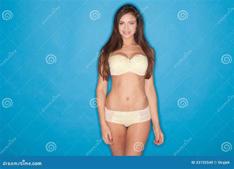 Femme Sexy Avec Un Beau Corps Se Tenant Posant Dans La Lingerie Jaune Et Tripotant Ses Longs