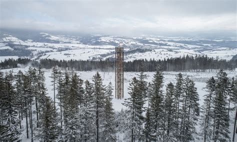 a lookout tower rises above the forested mountains of a czech ski area