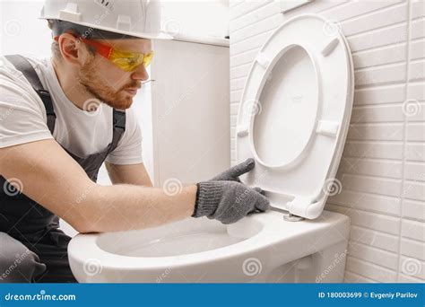 Plumber Installing Toilet Bowl In Restroom Work In Bathroom Stock