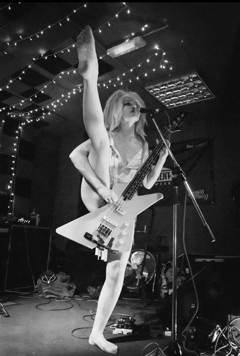 A Woman In White Dress Playing Guitar On Stage