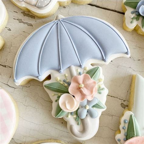 Decorated Cookies With An Umbrella And Flowers On Them Next To Some