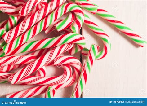 Lots Of Candy Canes Scattered On White Rustic Wooden Desk Chtistmas