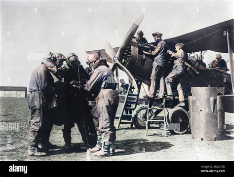 A British Bristol F2B biplane with members of 22 Squadron on an airfield, being prepared for ...