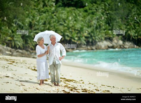 Happy elderly couple resting on tropical beach Stock Photo - Alamy