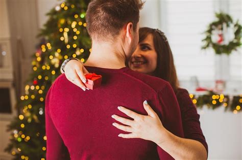 Vista traseira do jovem casal romântico abraçando mulher sorrindo e