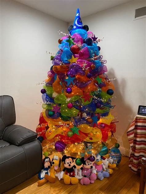 A Colorful Christmas Tree With Mickey Mouse Balloons On It S Bottom And Other Decorations