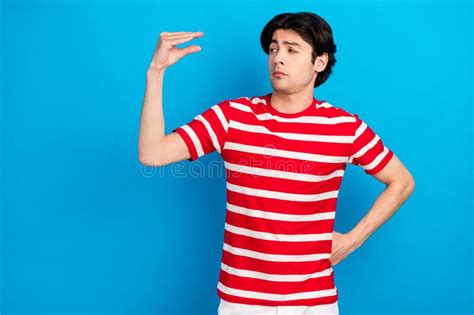 Photo Of Doubtful Funny Young Man Wear Striped T Shirt Measuring