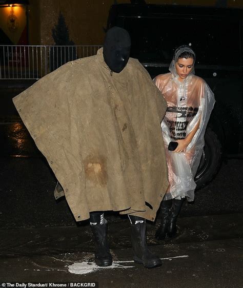 Bianca Censori S Attempt To Maintain Her Modesty While Posing Nude In A Clear Raincoat During