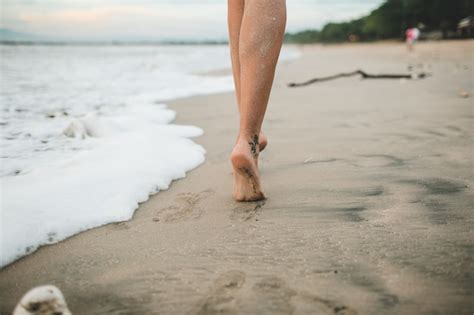 A menina está andando na praia Foto Grátis