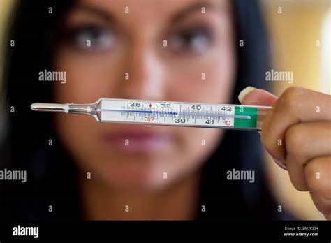 Woman Showing A Mercury Thermometer With Increased Body Temperature