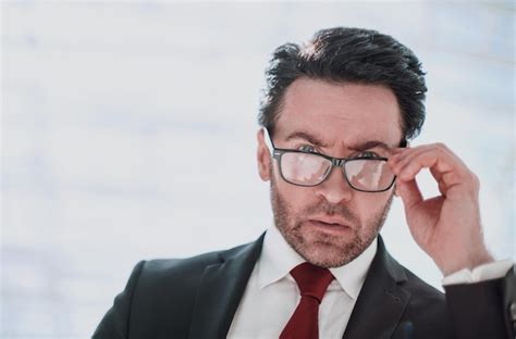 Premium Photo Serious Businessman Looks Over His Glasses