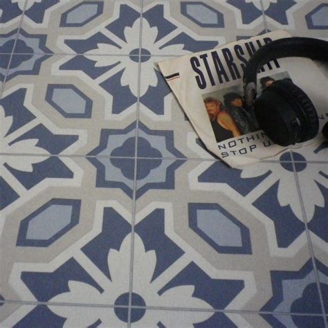 A Pair Of Headphones Laying On Top Of A Blue And White Tile Pattern Floor