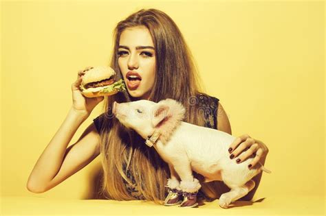 Muchacha Que Come La Hamburguesa Con El Cerdo Imagen De Archivo