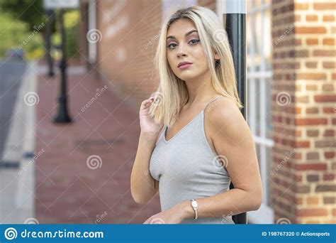 A Young Lovely Blonde Model Poses Outdoors While Enjoying A Summers Day