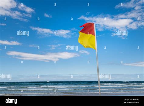 Bandera roja y amarilla en la playa fotografías e imágenes de alta