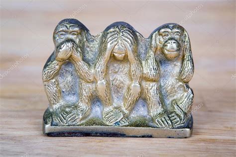 Brass statue of three monkeys isolated on wooden surface. — Stock Photo ...