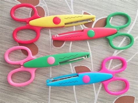 Several Different Colored Scissors Are Laying On A Table Top With Holes