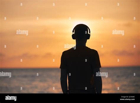 Silueta del hombre con auriculares contra el océano Serenidad