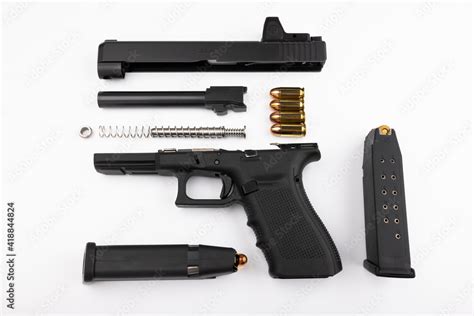 Parts of .45 semi automatic pistol handgun with bullets on white background , Gun disassembled ...