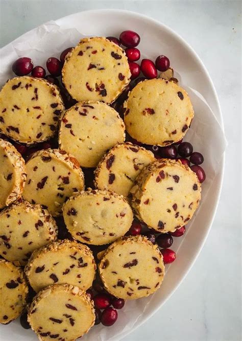 A White Bowl Filled With Cookies And Cranberries