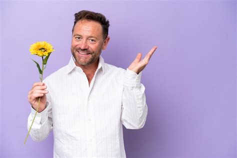 Hombre caucásico de mediana edad sosteniendo una flor de sol aislada en