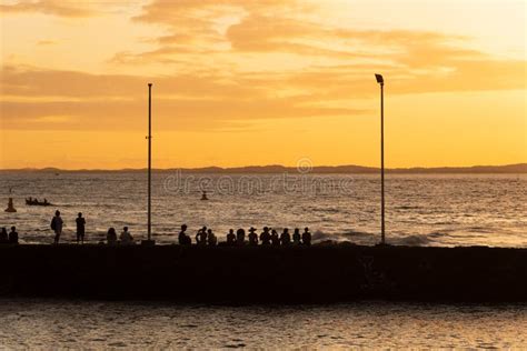 Silhouette Of People At Sunset On The Porto Da Barra Pier Editorial