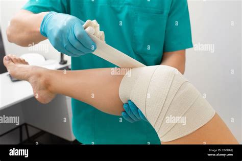 Patients Knee Bandaging Process With An Elastic Bandage To Fix The