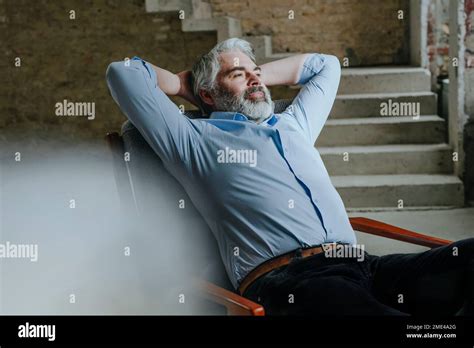 Thoughtful Mature Architect Resting In Chair At Construction Site Stock