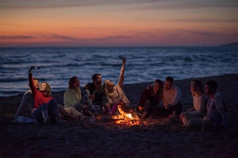 A Group Of Friends Enjoying Bonfire On Beach 12645661 Stock Photo At