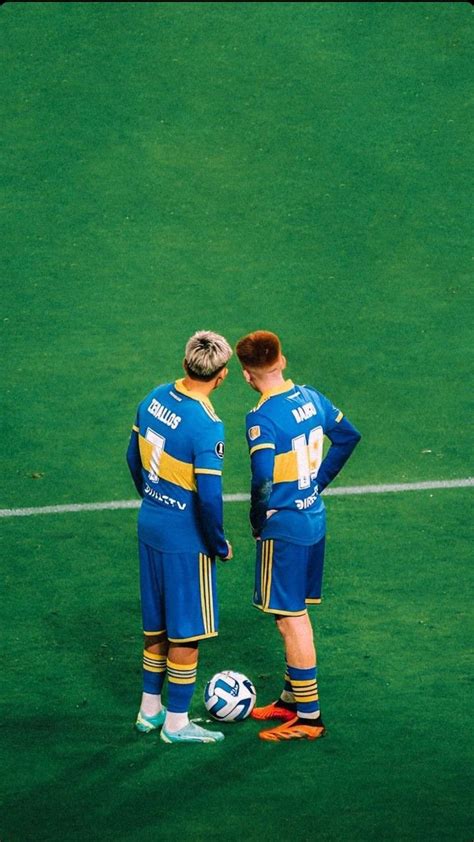 Two Soccer Players Standing Next To Each Other With Their Hands On