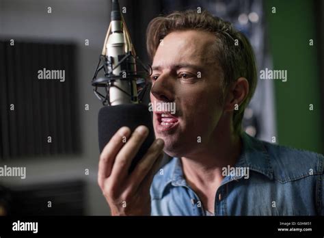 Man Singing Into Microphone In Recording Studio Stock Photo Alamy