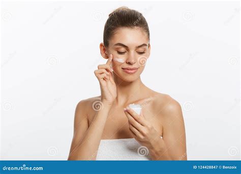 Retrato De La Mujer Joven Que Aplica La Crema De La Crema Hidratante En