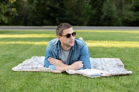 Premium Photo Young Man In Sunglass Relaxing And Reading Book While