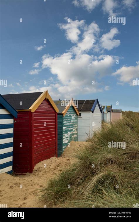 A Row Of Colourful Beach Huts Under A Blue Sky At Southwold Beach In