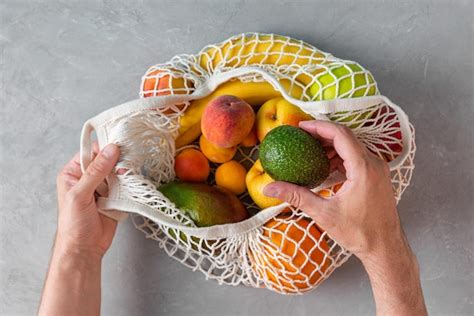 Premium Photo Men Hand Taking Avocado From Mesh Shopping Bags With