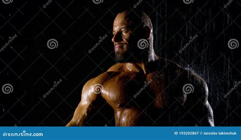 Muscular Man Shows His Muscles Against The Background Of A Black Wall Bodybuilder Male Naked