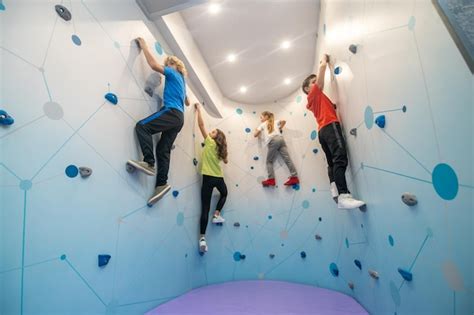 Free Photo Schoolchildren In Training Hanging On Climbing Wall