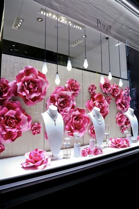 A Display Window With Pink Flowers And Vases