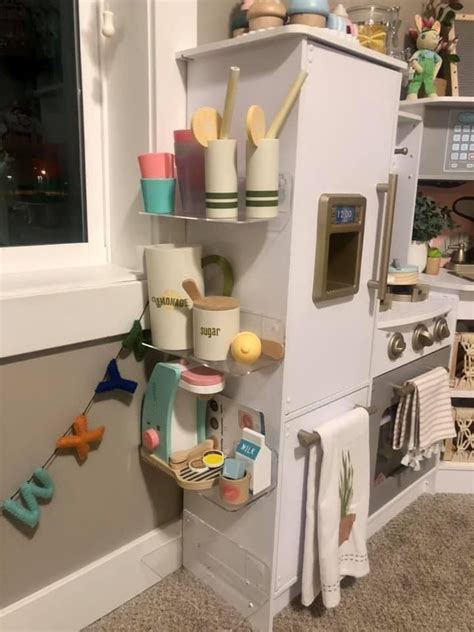 A Toy Kitchen Is Shown With Toys On The Shelves